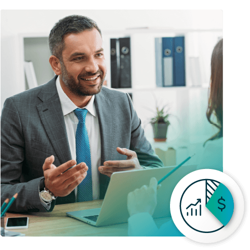 A businessman talking with a colleague at a laptop, with an icon of a pie chart and dollar sign