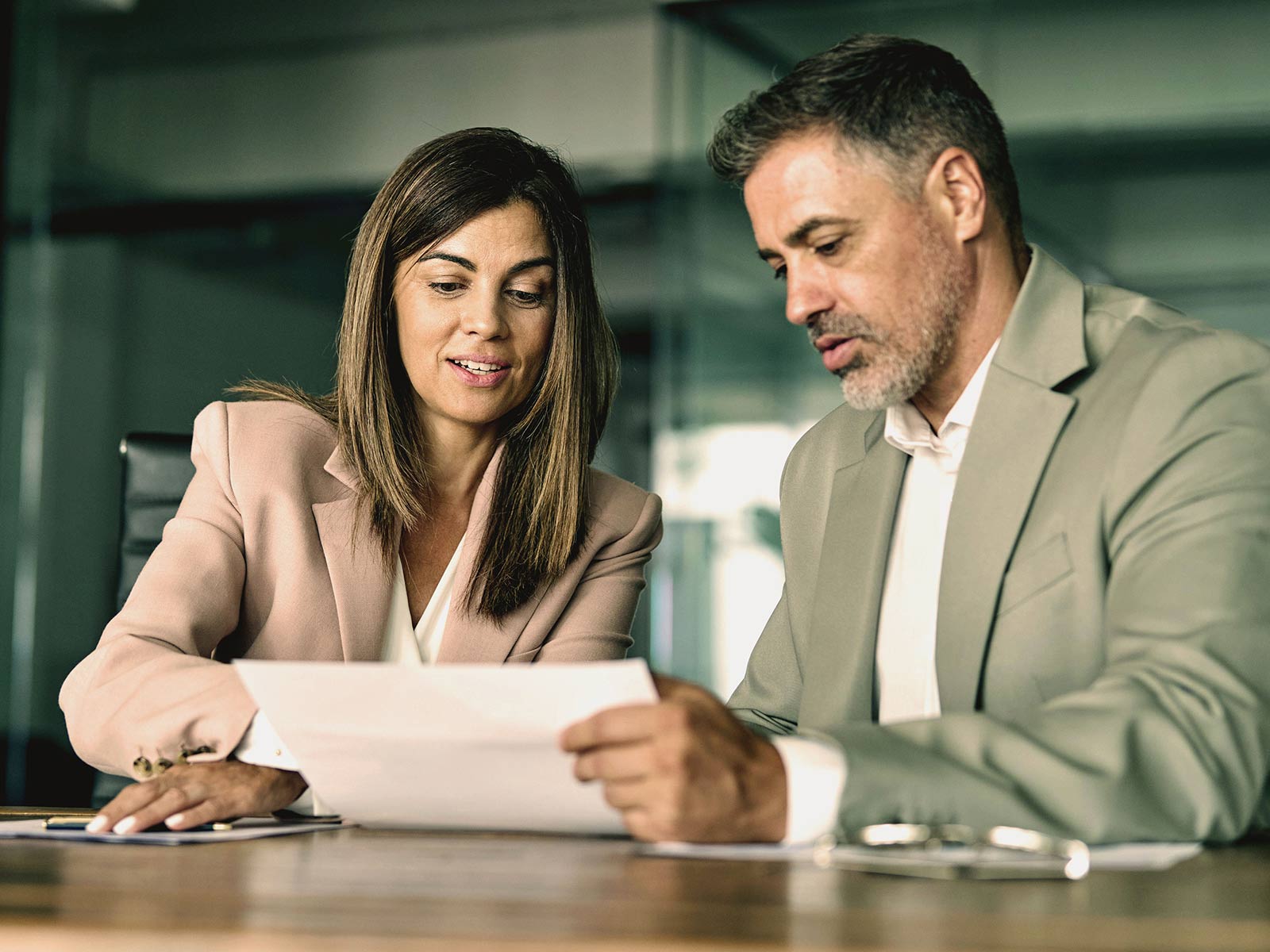 Two business professionals reviewing a document together at a conference table